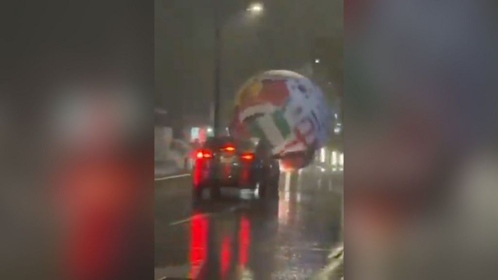 Giant World Cup ball whips through streets in wild weather